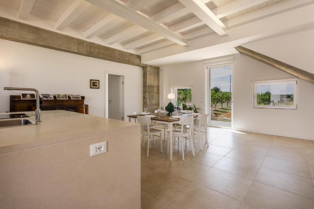 une cuisine et un salon avec une table et des chaises dans l'établissement Villa Mandorlo - IsulaTravel, à Noto