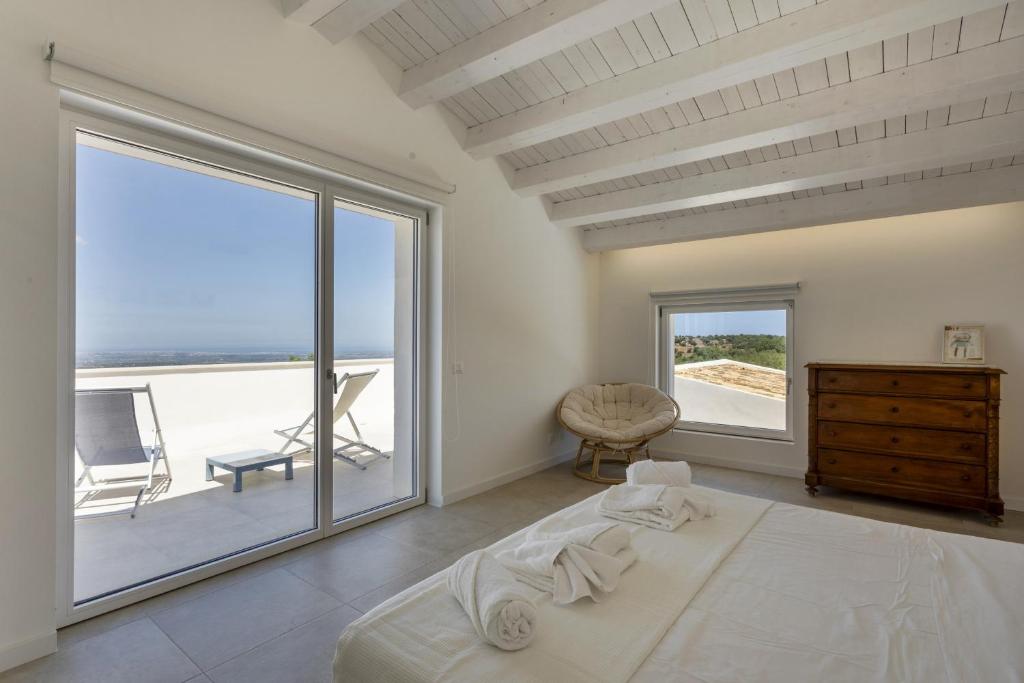 une chambre avec un lit et une grande fenêtre dans l'établissement Villa Mandorlo - IsulaTravel, à Noto