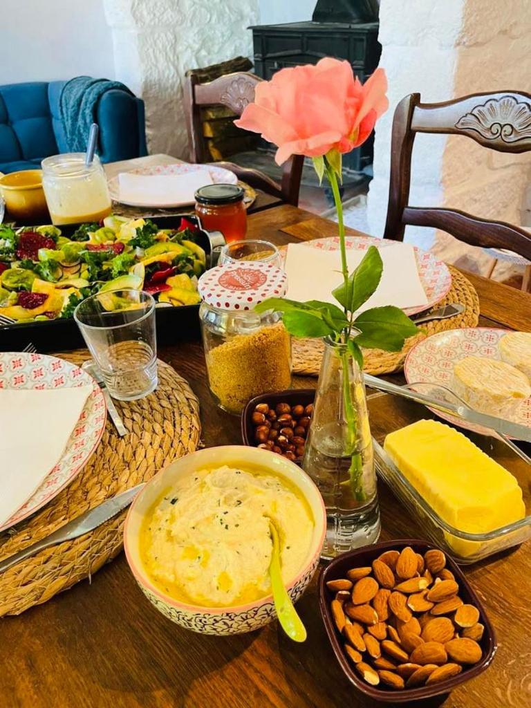 une table avec des assiettes de nourriture et un vase avec une fleur dans l'établissement Yourte Maison Oya, à Montréal