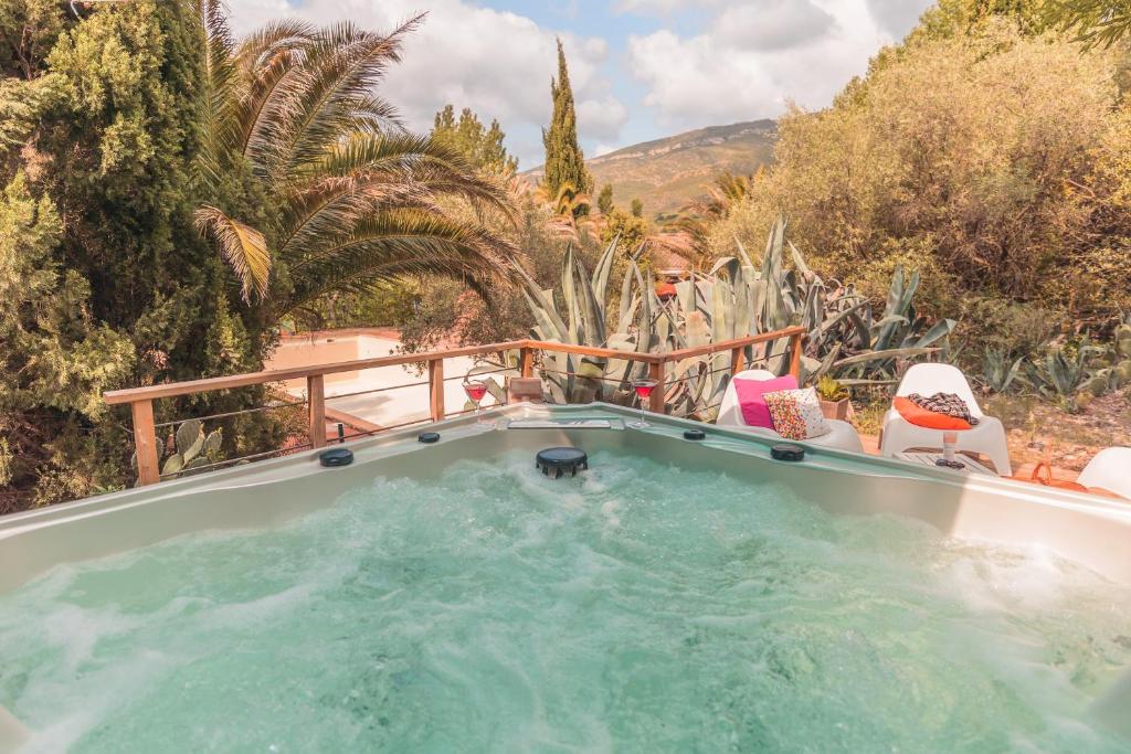 un bain à remous dans un jardin avec des chaises et des cactus dans l'établissement Tente évasion, à Tuchan