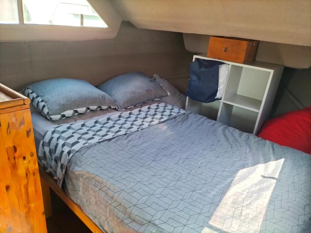 une chambre avec un lit dans une petite pièce dans l'établissement Bateau PEARL, à Rouen