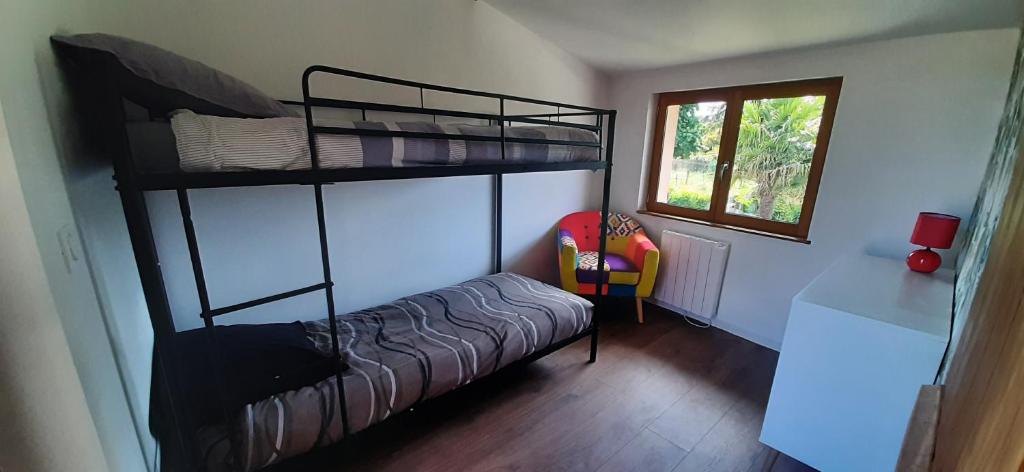 - une chambre avec 2 lits superposés et une chaise dans l'établissement Le gîte de Pierre, à Rieux