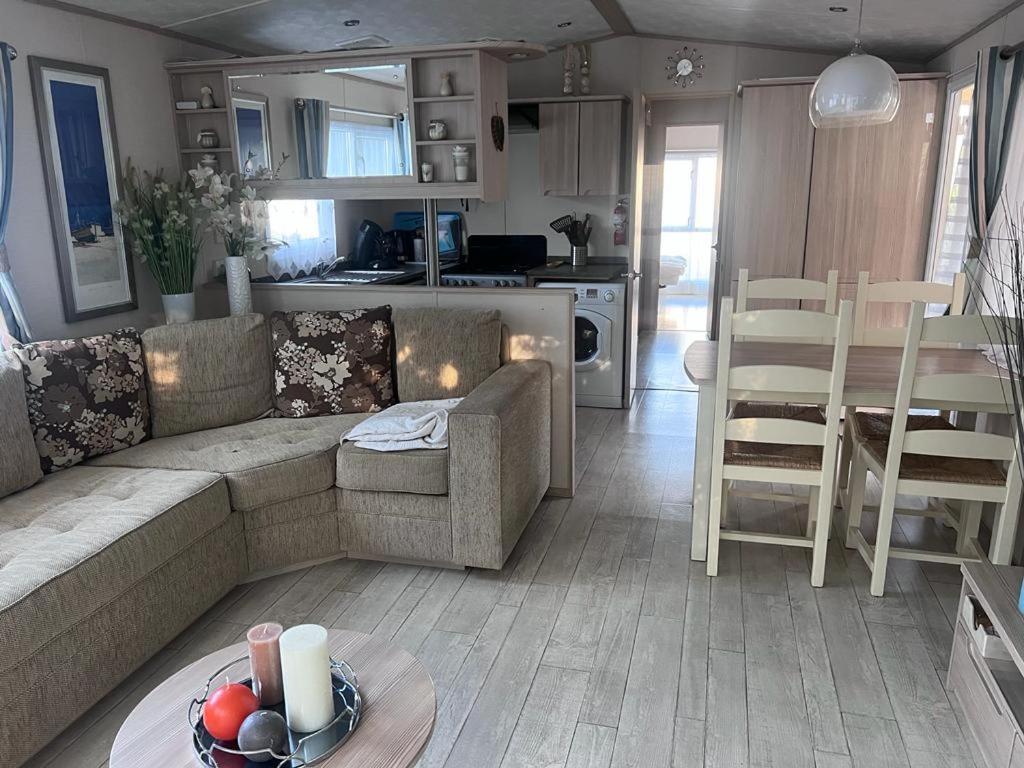 un salon et une cuisine avec un canapé et une table dans l'établissement Mobil home le Montourey, à Fréjus
