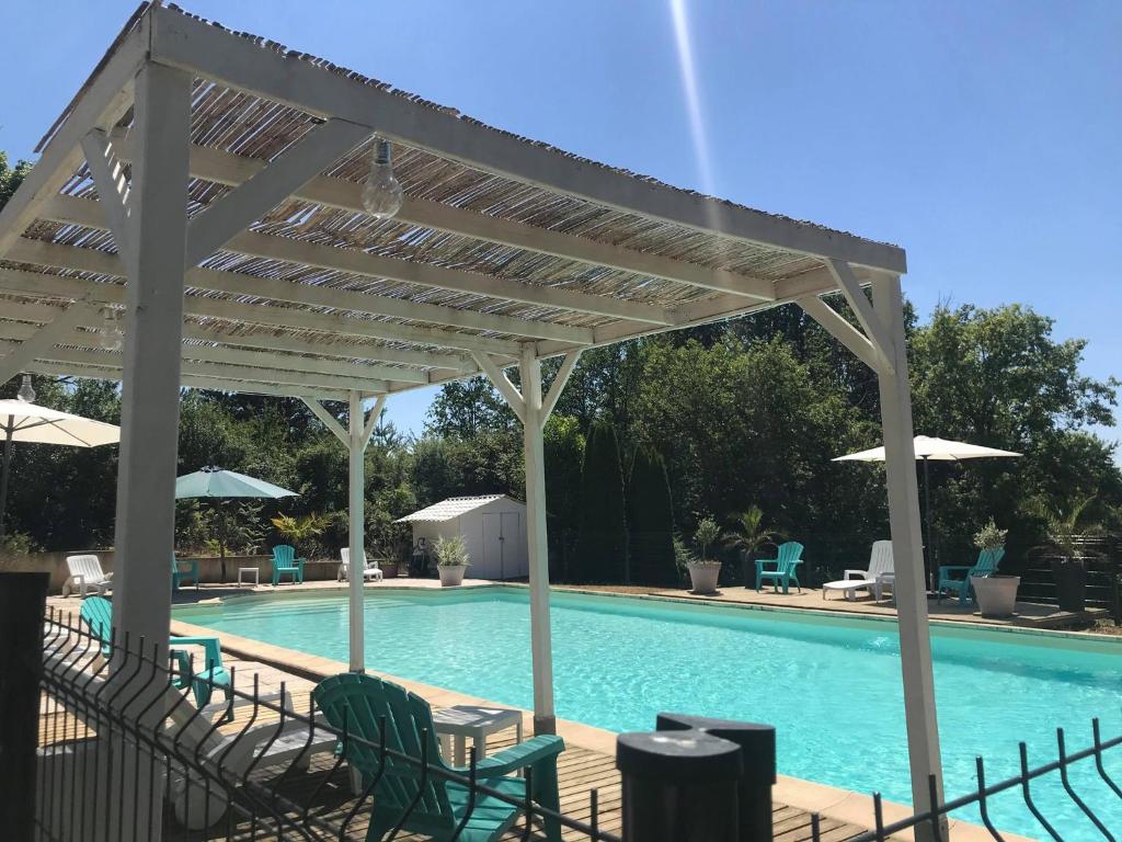 un pavillon au-dessus d'une piscine avec des chaises et des parasols dans l'établissement CAMPING HERMITAGE DES 4 SAISONS, à Saint-Julien-de-Bourdeilles 13 autres photos
