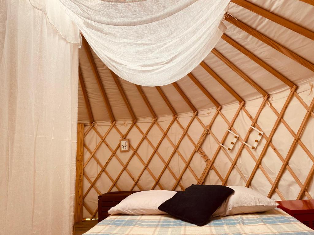 une chambre avec un lit dans une yourte dans l'établissement Yourte et son bain nordique, à Fréchet-Aure