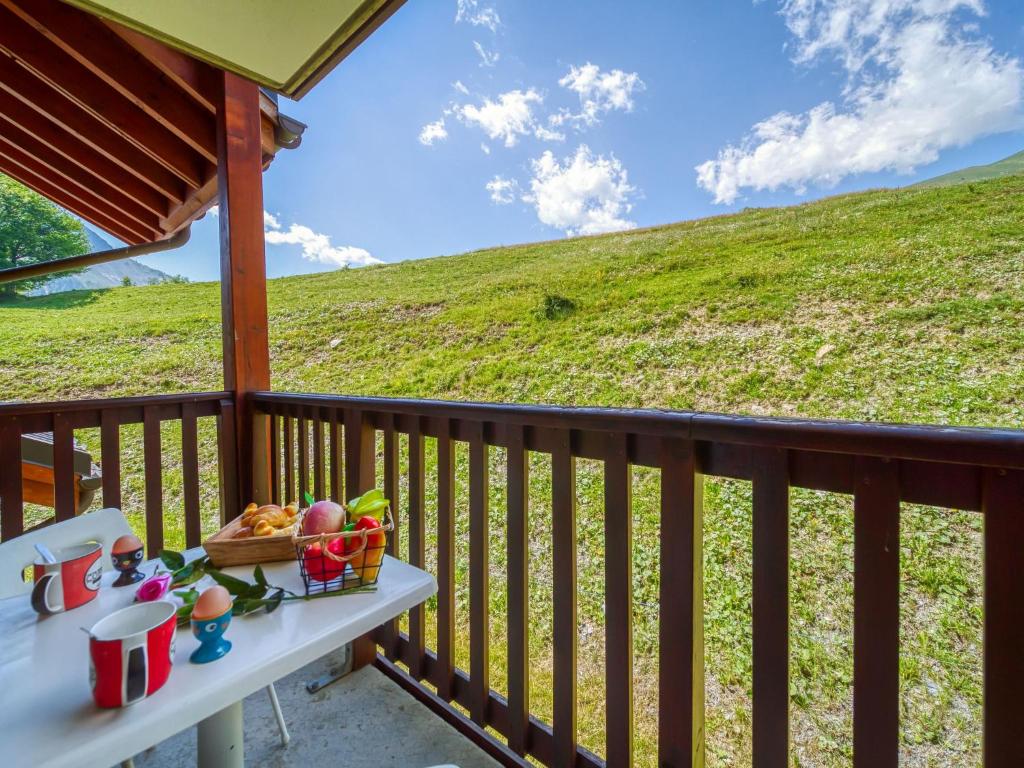 - une table sur un balcon avec vue sur une colline dans l'établissement Apartment Les Alpages du Corbier-1 by Interhome, au Corbier