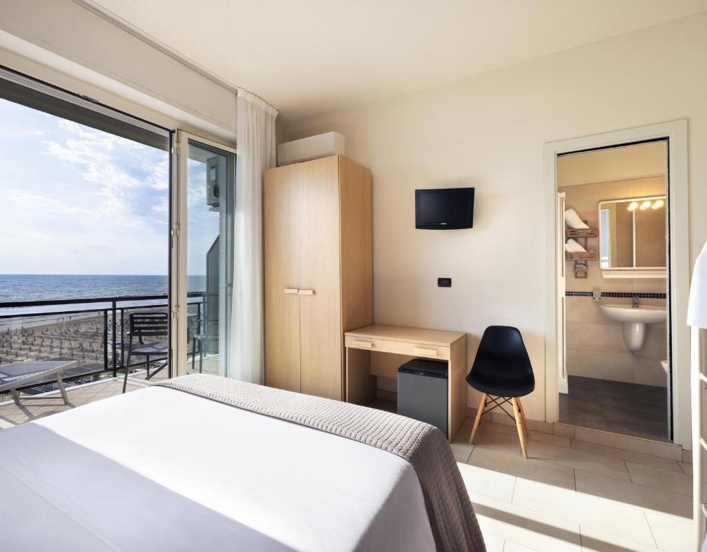 une chambre avec un lit et une vue sur l'océan dans l'établissement Hotel Constellation, à Lido di Savio