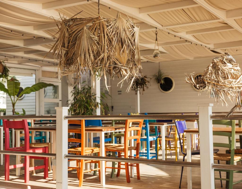 un restaurant avec des tables et des chaises colorées dans une salle dans l'établissement Hotel Constellation, à Lido di Savio