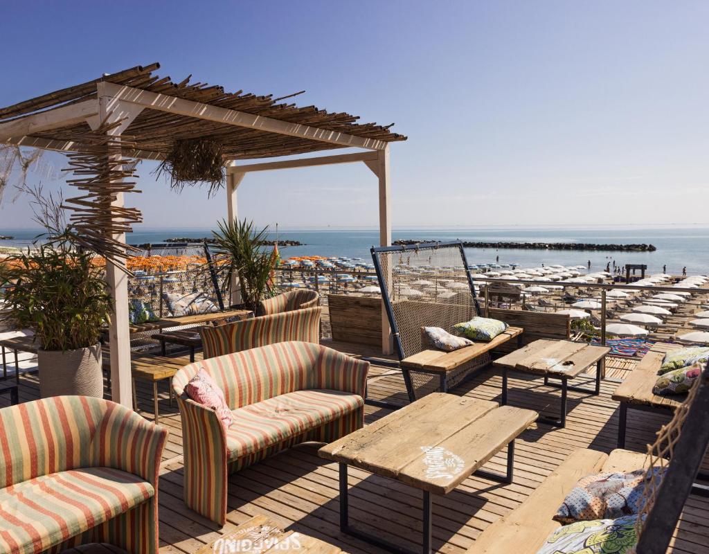 d'une terrasse avec des chaises et des tables offrant une vue sur l'océan. dans l'établissement Hotel Constellation, à Lido di Savio