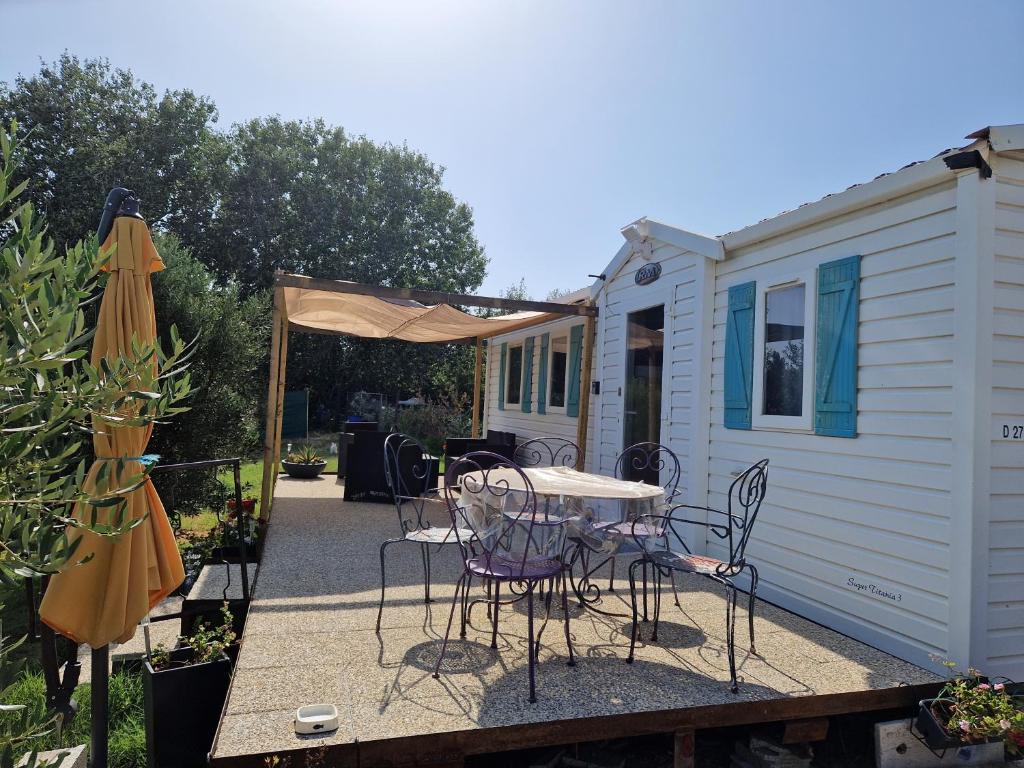 une terrasse avec une table et des chaises à côté d'une caravane dans l'établissement Mazet d El gato, à Arles