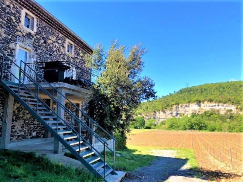 un escalier à côté d'un bâtiment à côté d'un champ dans l'établissement Gîte 12-14p avec vue piscine chauffée en saison, terrain de pétanque et jeux extérieurs, à Alba-la-Romaine