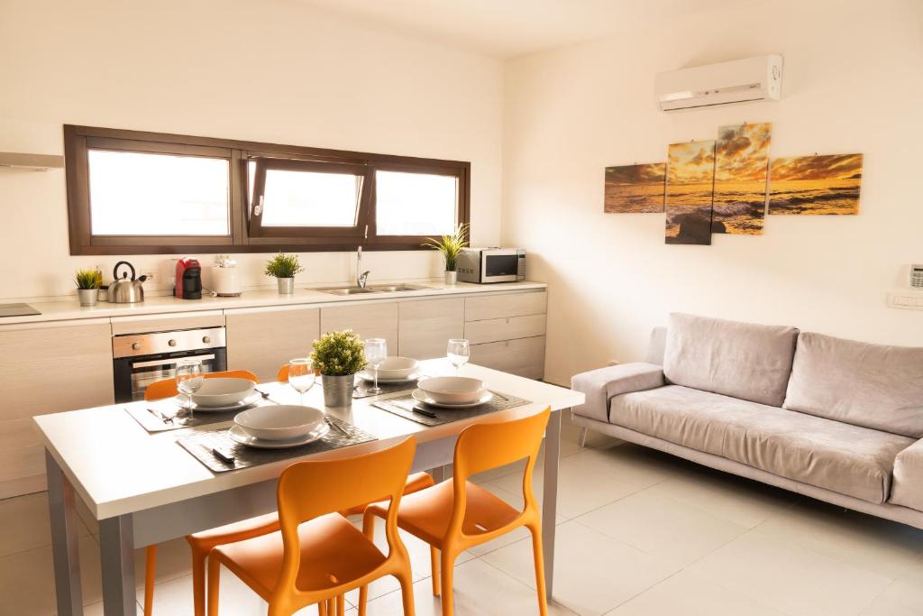 une cuisine et un salon avec une table et des chaises dans l'établissement Ville Edilia Vacanze, à Marina di Ragusa
