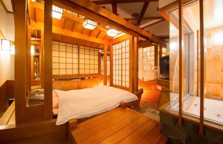 une chambre avec un lit dans une pièce avec des fenêtres dans l'établissement ホテル　アイネ　香芝店, à Kashiba