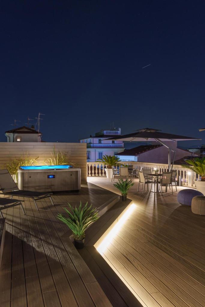 - une terrasse avec une table et des chaises la nuit dans l'établissement Vi Suites, à Viareggio