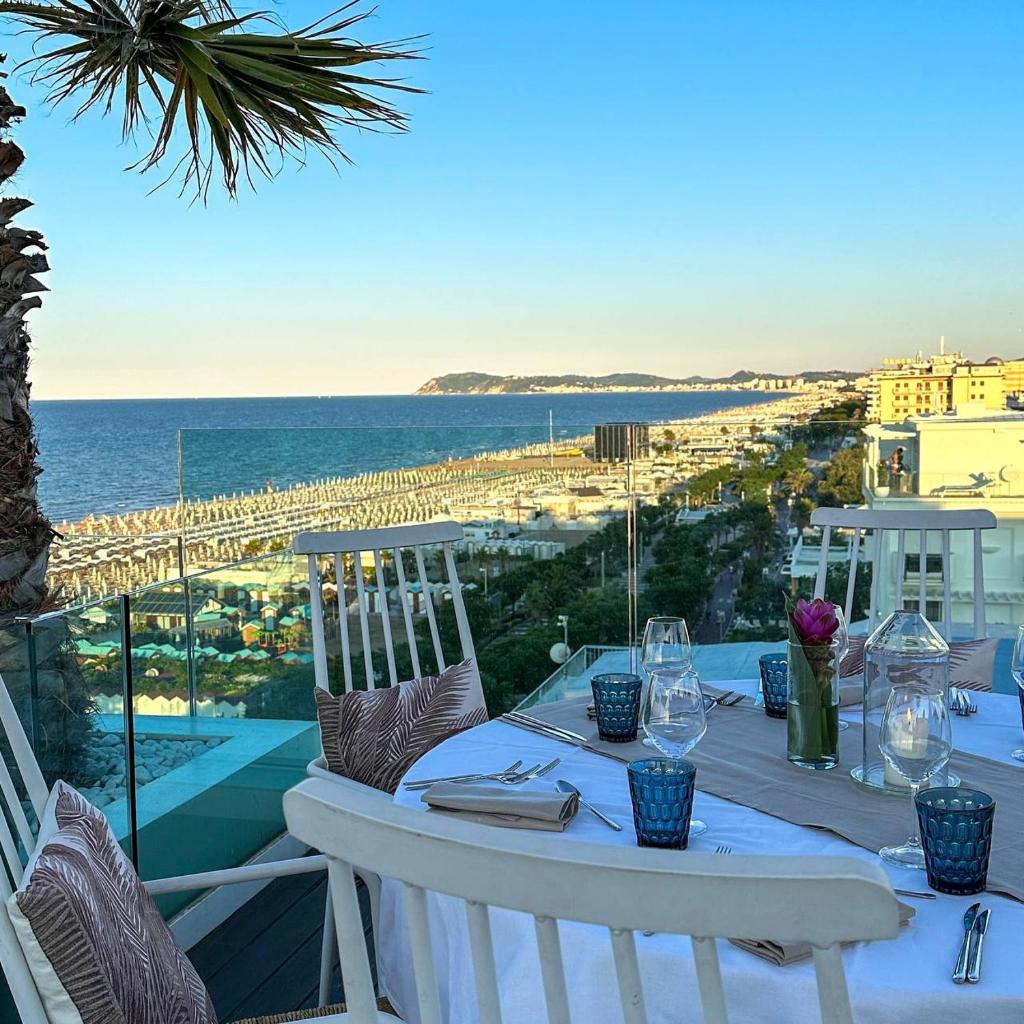 une table sur un balcon avec vue sur l'océan dans l'établissement Hotel Lungomare, à Riccione