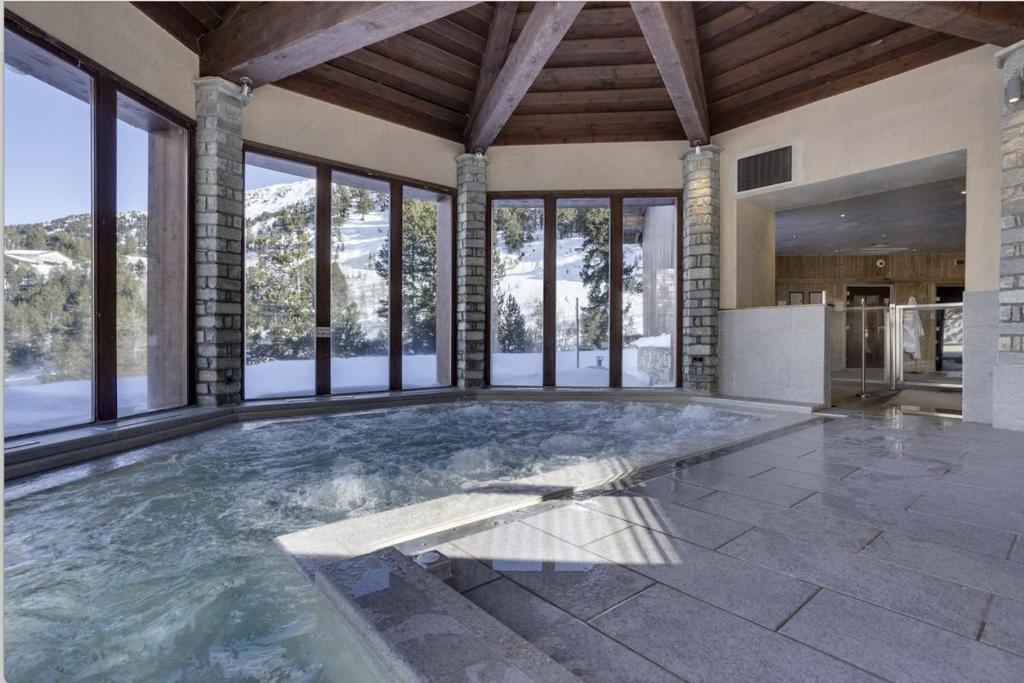 - une grande piscine dans une maison dotée de fenêtres dans l'établissement ARC 1950 Appt 6/8 pers LUXE MANOIR SAVOIE - SKI IN SKI OUT, à Arc 1950