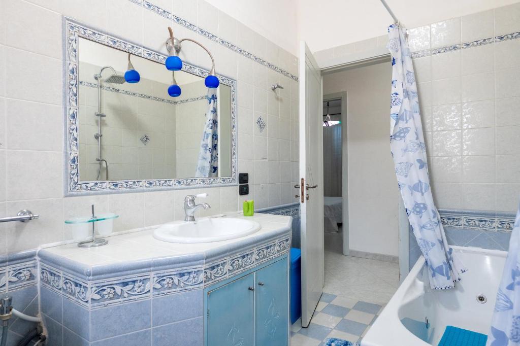 une salle de bain avec un lavabo, une baignoire et un miroir dans l'établissement Villa Altavilla with pool, à Ceglie Messapica