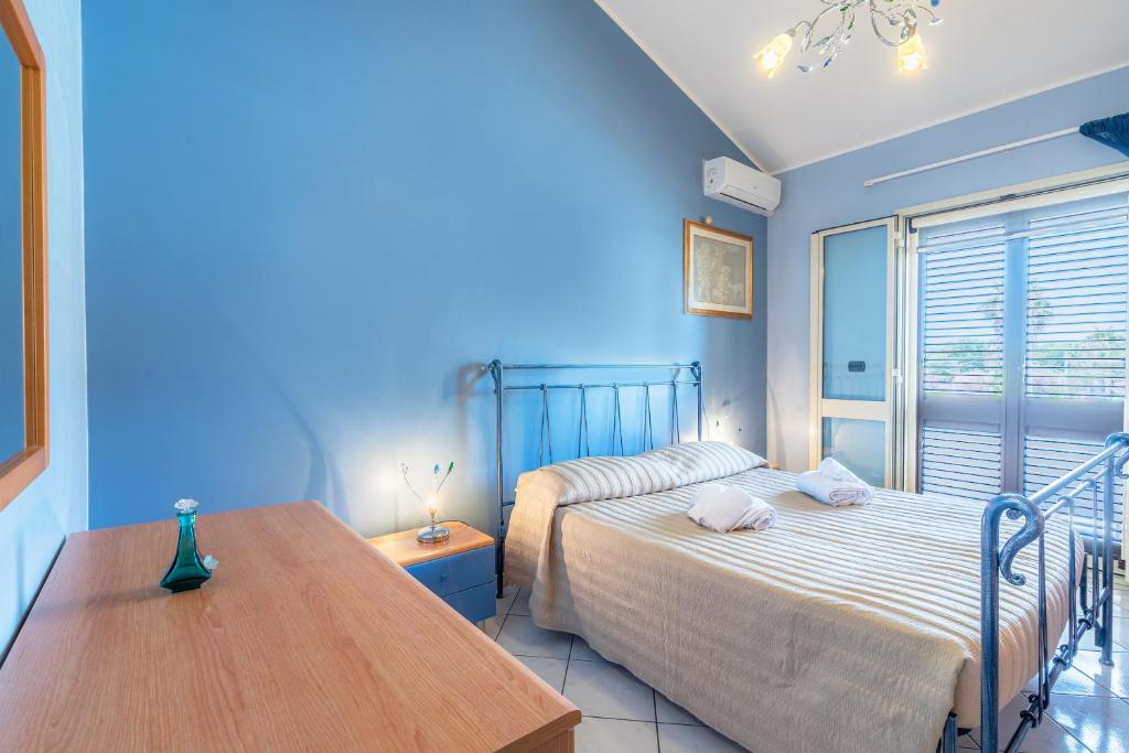 - une chambre avec 2 lits et une table en bois dans l'établissement Villa Raffa, à Avola