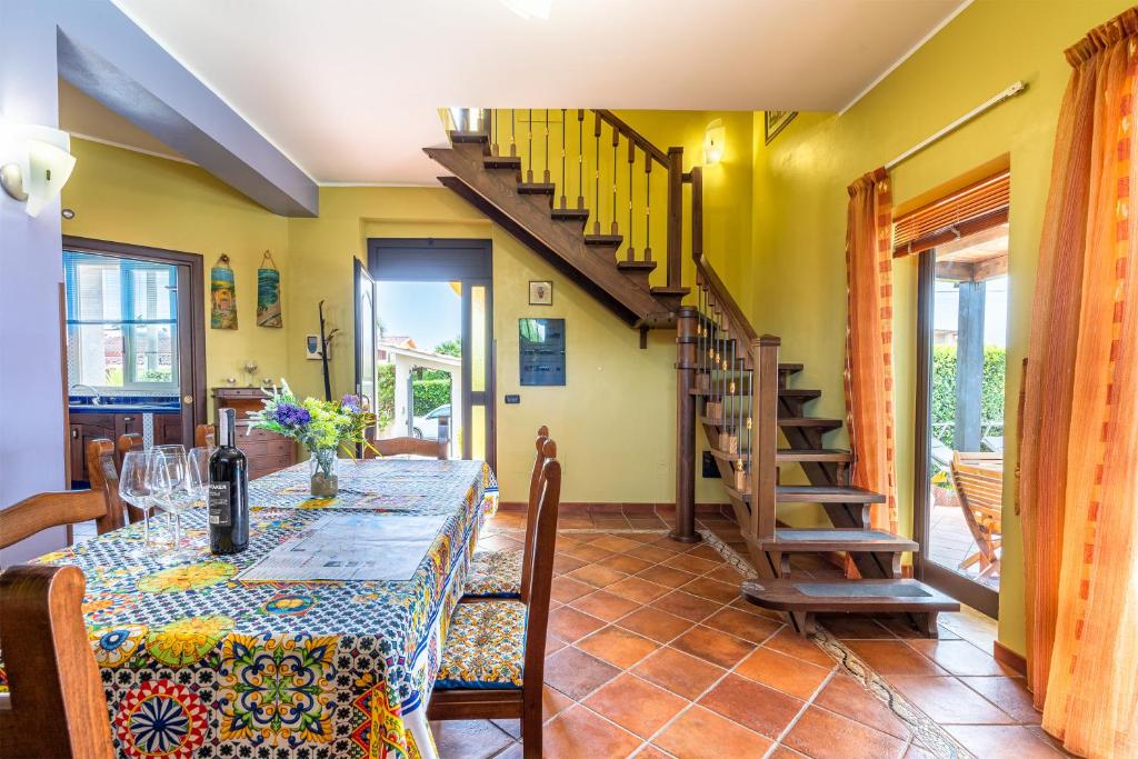 une salle à manger avec une table et un escalier dans l'établissement Villa Raffa, à Avola