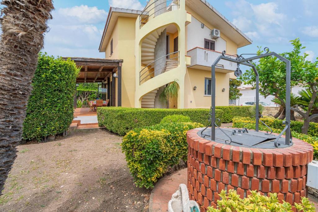 une maison avec une fontaine en briques devant elle dans l'établissement Villa Raffa, à Avola