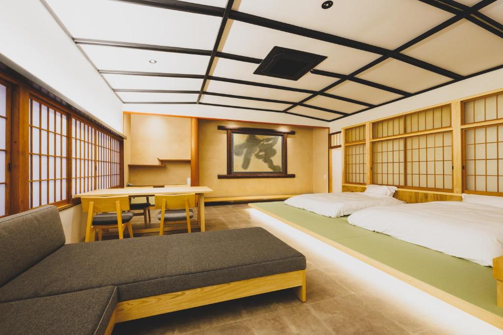 une chambre d'hôtel avec deux lits et une table dans l'établissement Ryokan Masuya, à Ōda