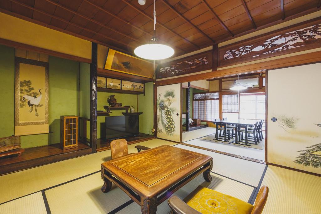 un salon avec une table et des chaises en bois dans l'établissement Ryokan Masuya, à Ōda