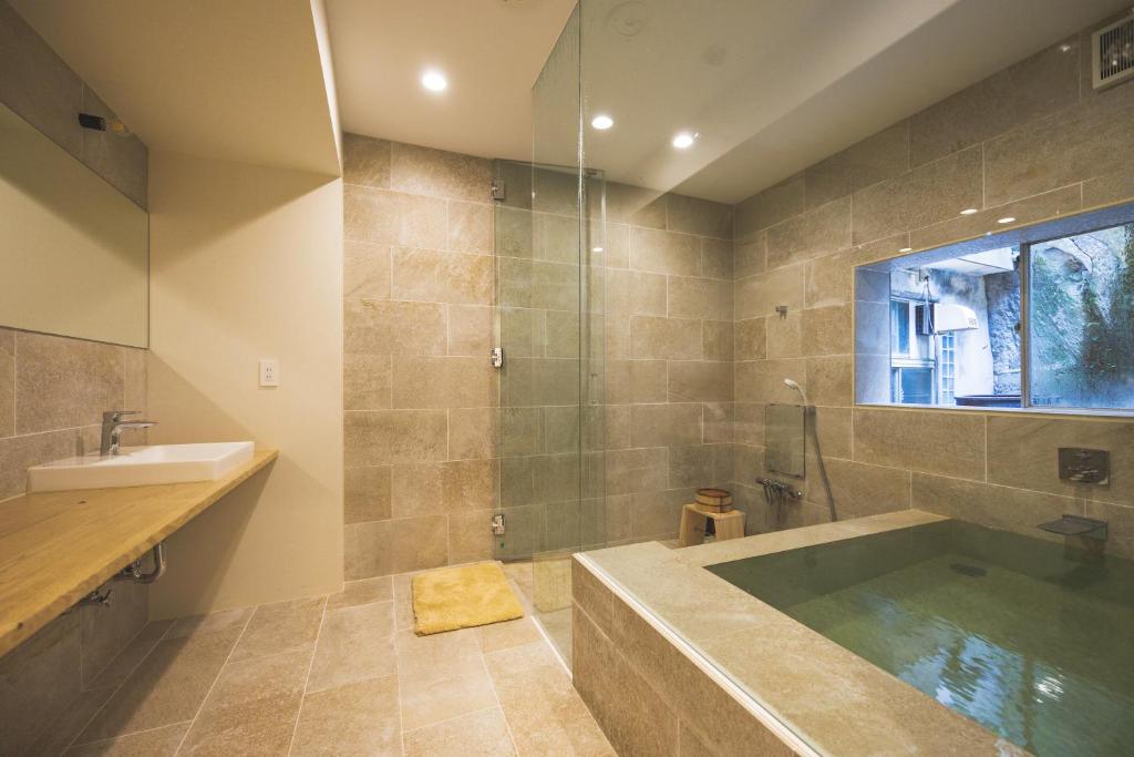 une salle de bain avec une baignoire et un lavabo dans l'établissement Ryokan Masuya, à Ōda 153 autres photos