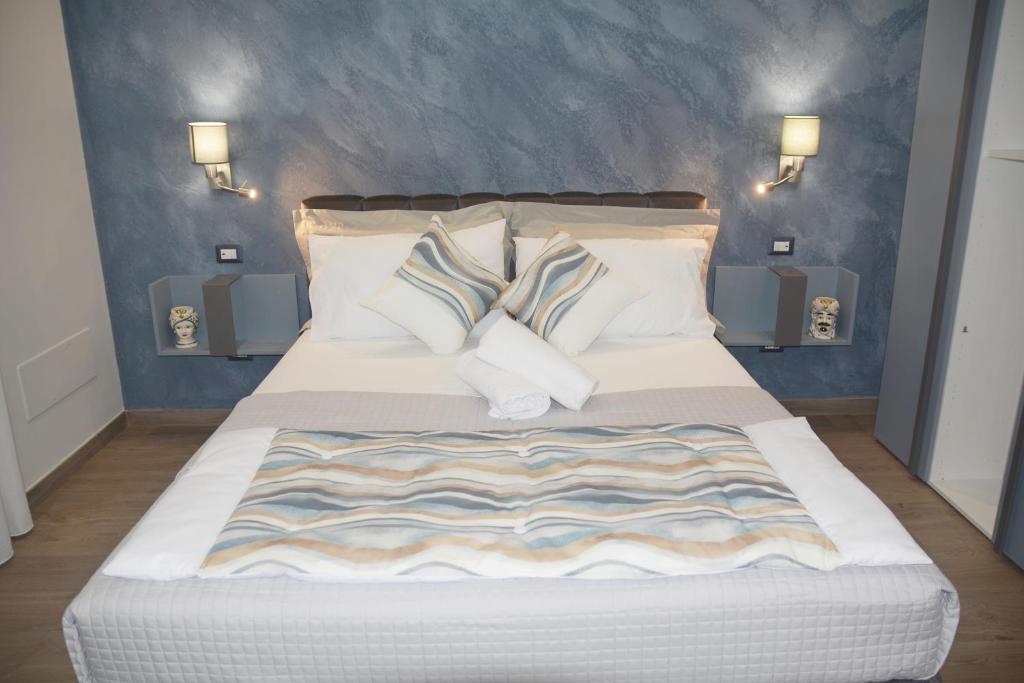 une chambre avec un grand lit blanc avec des oreillers dans l'établissement Triskelion, à Nunziata