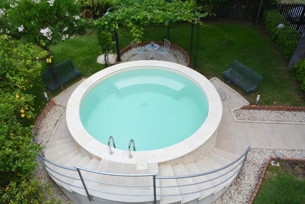 - une grande piscine dans une cour avec deux bancs dans l'établissement Triskelion, à Nunziata