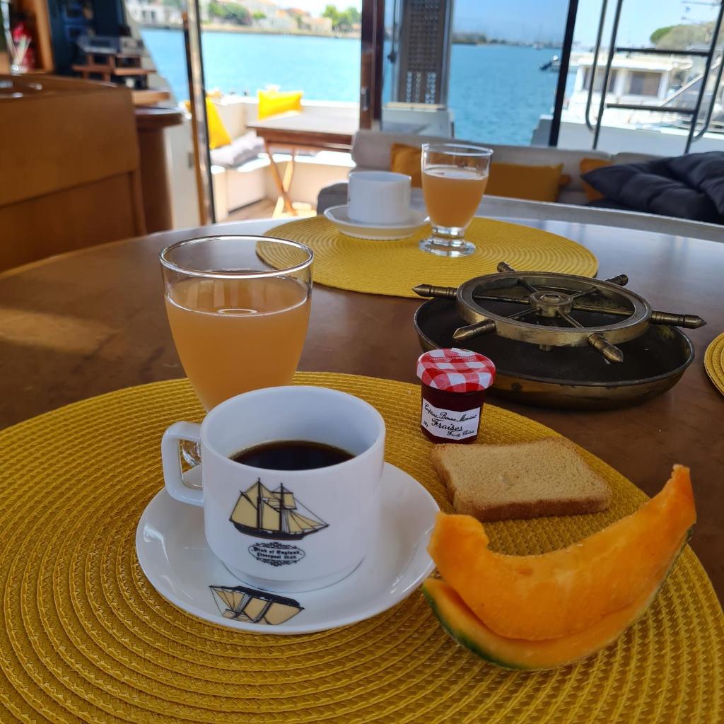 - une table avec une tasse de café et un morceau de pain dans l'établissement Nuit insolite bateau à quai - Port Saint Louis du Rhône, à Port-Saint-Louis-du-Rhône 27 autres photos