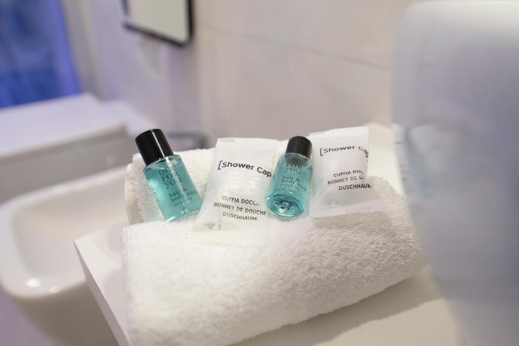 une salle de bain avec deux bouteilles de savon et des serviettes dans l'établissement Park Hotel Valle Clavia, à Peschici