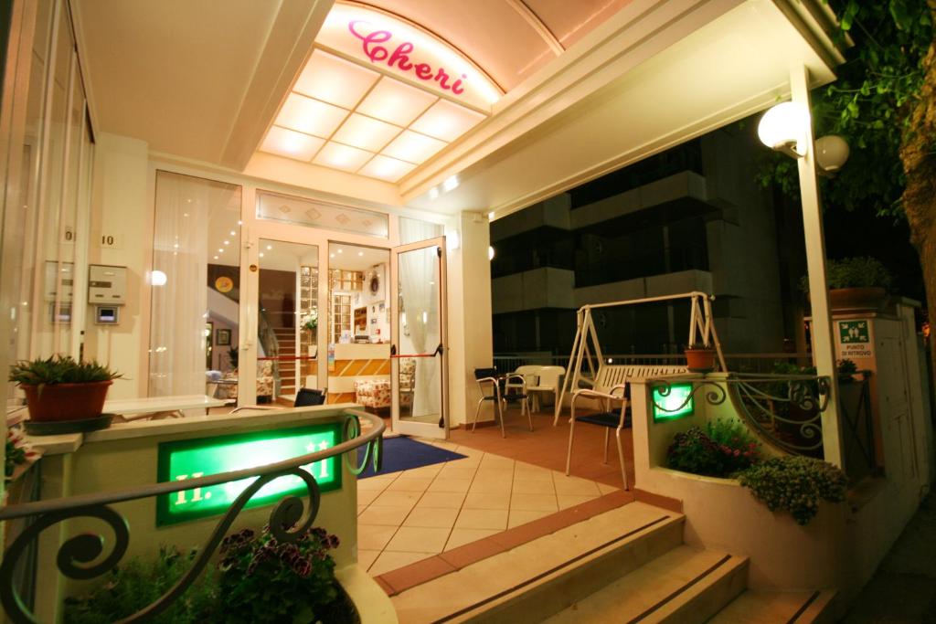 un magasin avec un signe néon à l'avant de celui-ci dans l'établissement Hotel Cheri, à Rimini