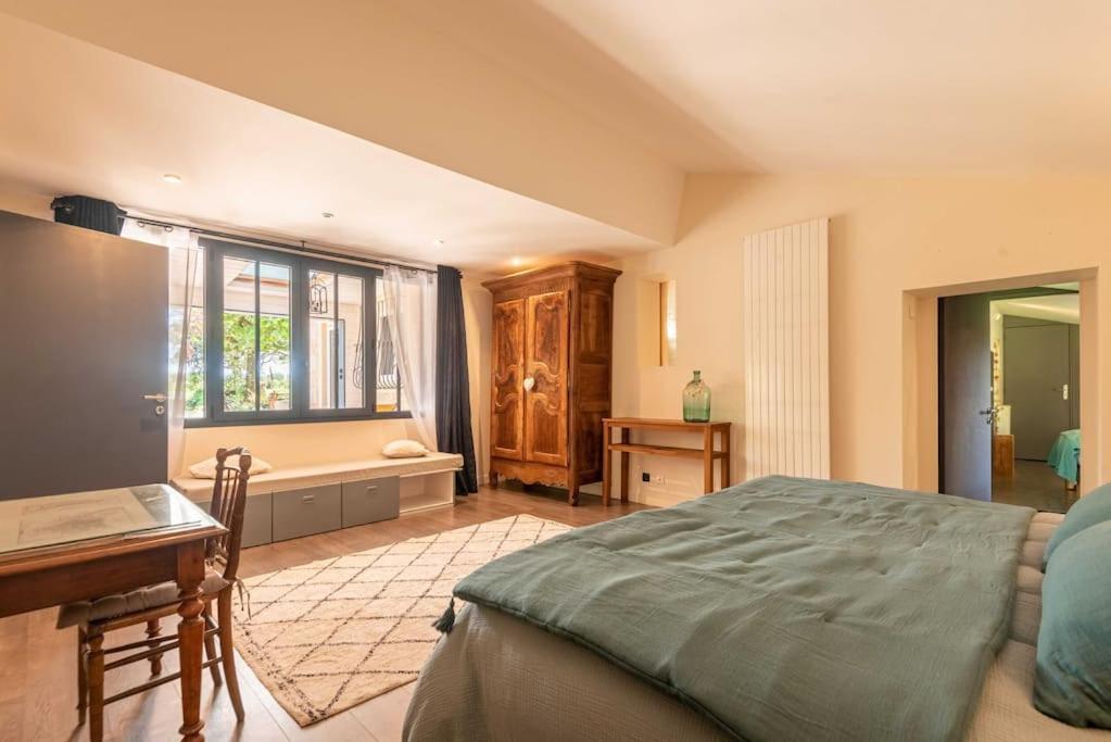 une chambre avec un lit, un bureau et une fenêtre dans l'établissement La Longère Bordeaux gite de charme avec piscine, à Cénac 37 autres photos