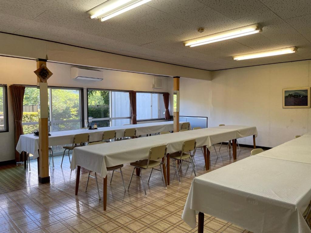 Cette chambre comprend des rangées de tables et de chaises. dans l'établissement Togawaso, à Fujikawaguchiko