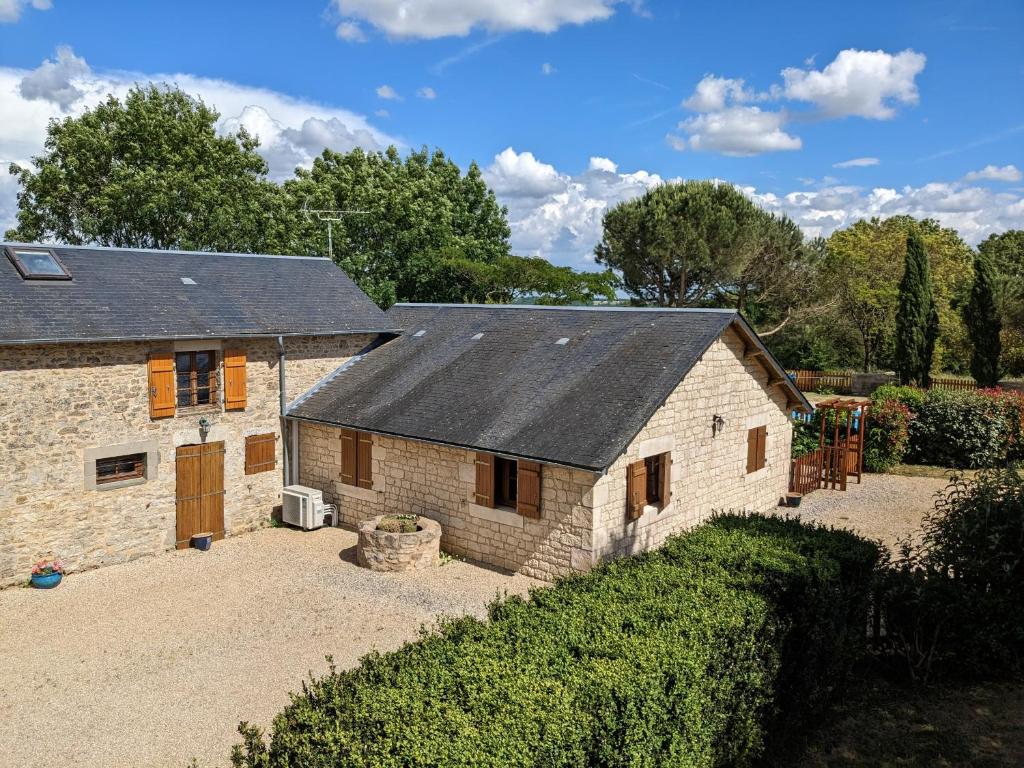 une ancienne grange en pierre avec un toit noir dans l'établissement 3 self-contained gites with pool and games room, à Saint-Georges-de-Noisné