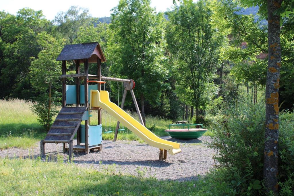 une aire de jeux avec un toboggan et un bateau dans l'établissement Village de chalets et camping La Pierre de l'Aigle, à La Bréole