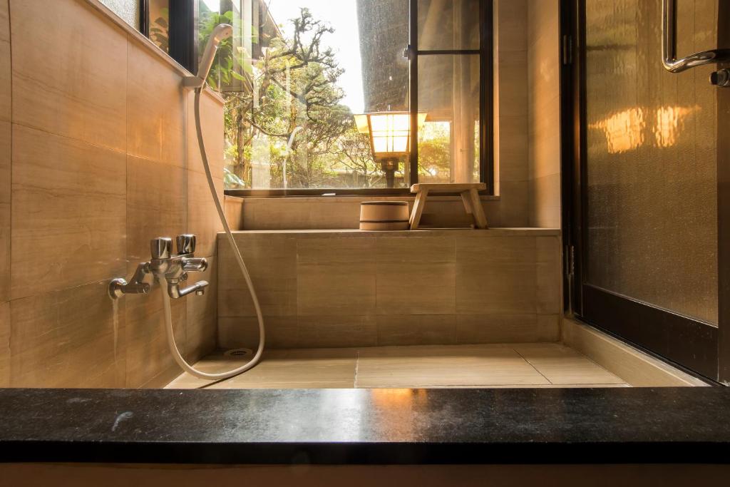 une salle de bain avec douche et fenêtre dans l'établissement Yamagaso, à Hakone