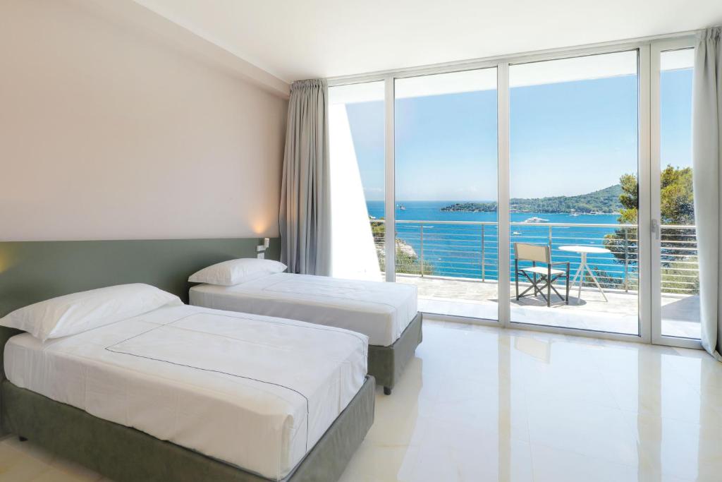une chambre d'hôtel avec deux lits et vue sur l'océan dans l'établissement Cristallo Park Hotel, à Portovenere