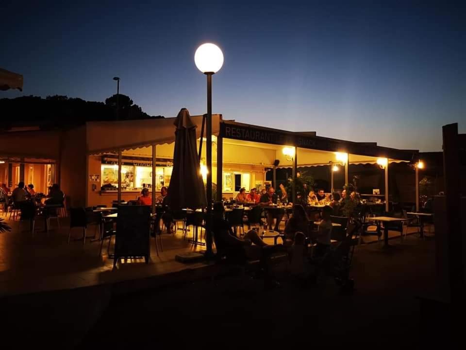 un groupe de personnes assises dans un restaurant la nuit dans l'établissement vacances familiales dans camping avec piscine, à Fréjus