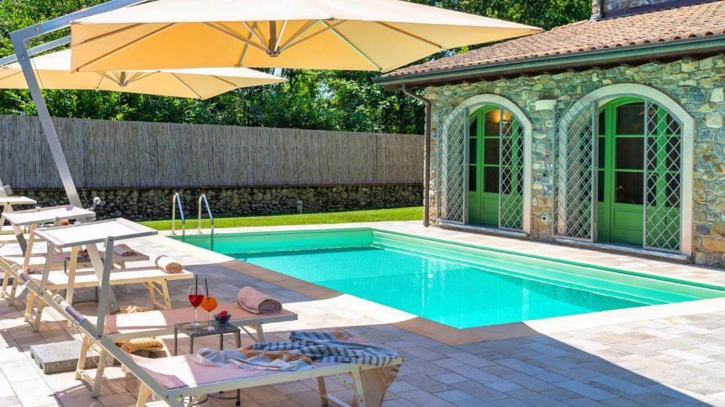 une piscine avec des chaises et un parasol dans l'établissement Villa Elsa 6, Emma Villas, à Filetto