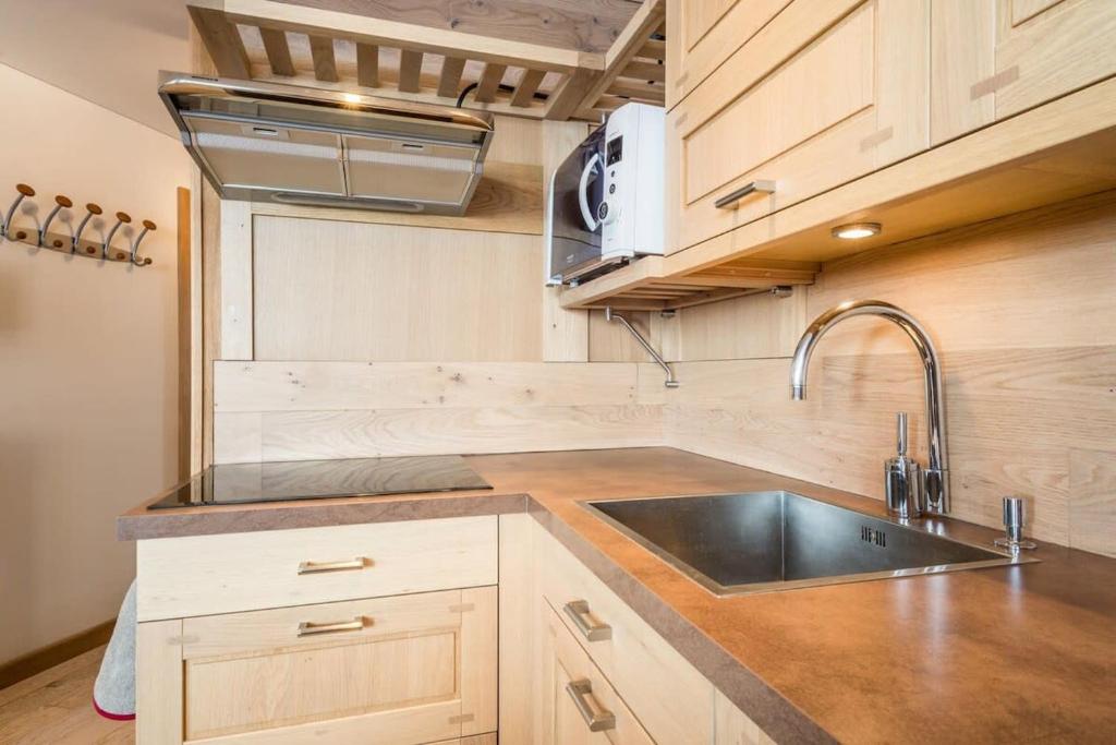 une cuisine avec un évier et une cuisinière dans l'établissement IMMODREAMS - Le Refuge, à Morzine