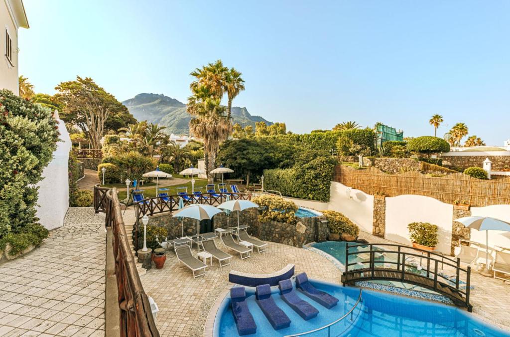 - une piscine avec des chaises longues et des parasols dans un complexe dans l'établissement Hotel Terme Tritone Resort & Spa, à Ischia