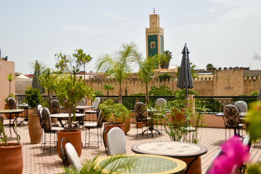 un patio extérieur avec tables, chaises et plantes dans l'établissement Riad Yacout, à Meknès