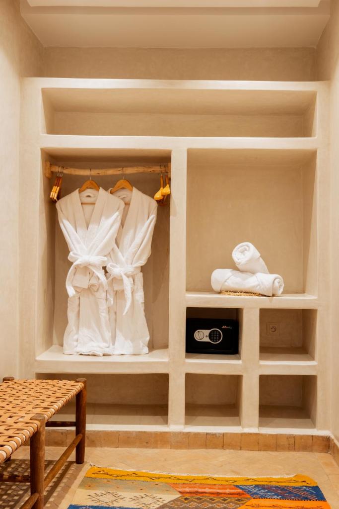 - un dressing avec des vêtements blancs sur les étagères dans l'établissement Le Palais Averroes - Adults Only, à Marrakech