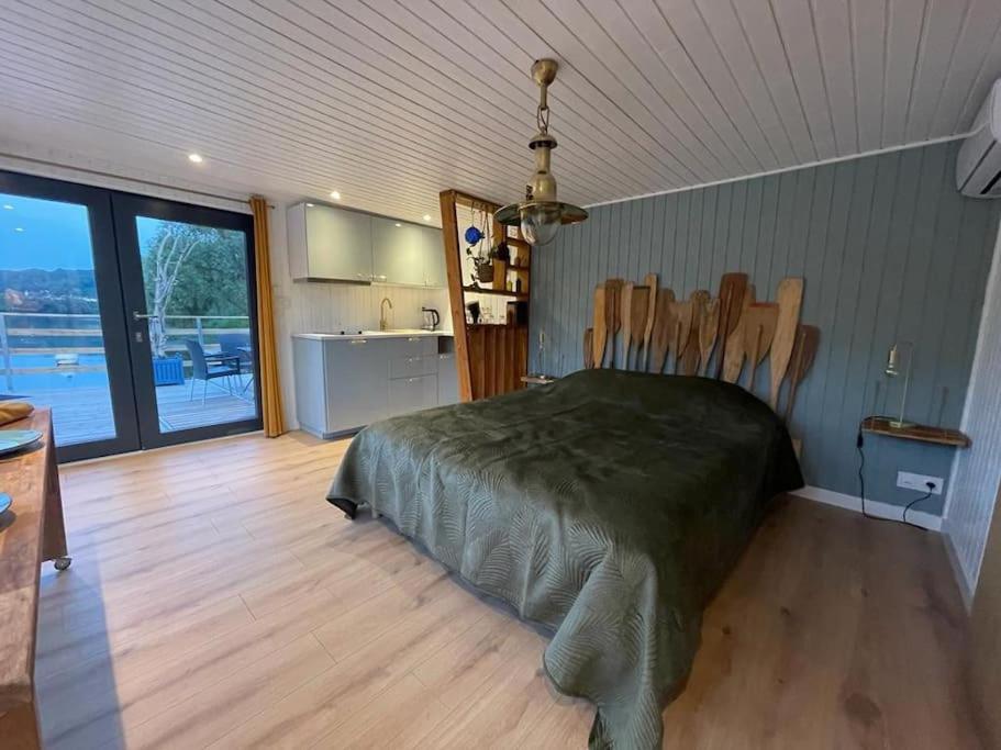 une chambre avec un grand lit et une cuisine dans l'établissement Rêve sur l’eau, à Moisson