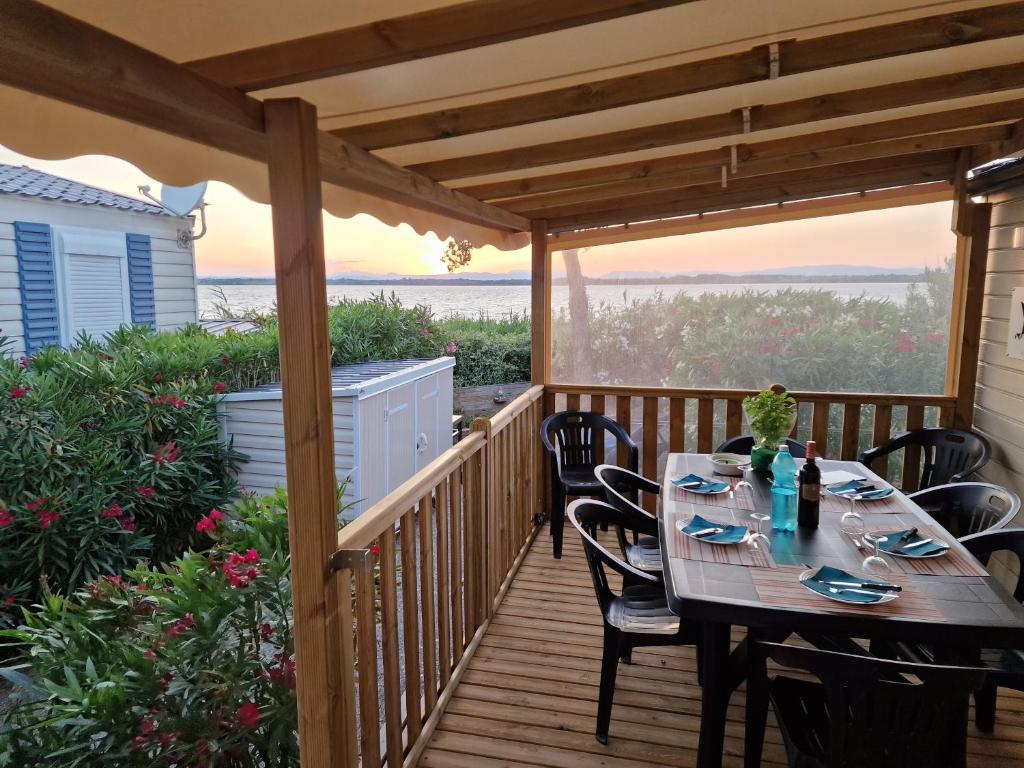 un patio avec une table et des chaises sur une terrasse dans l'établissement Mobile Home La Roulotte Catalane, à Canet