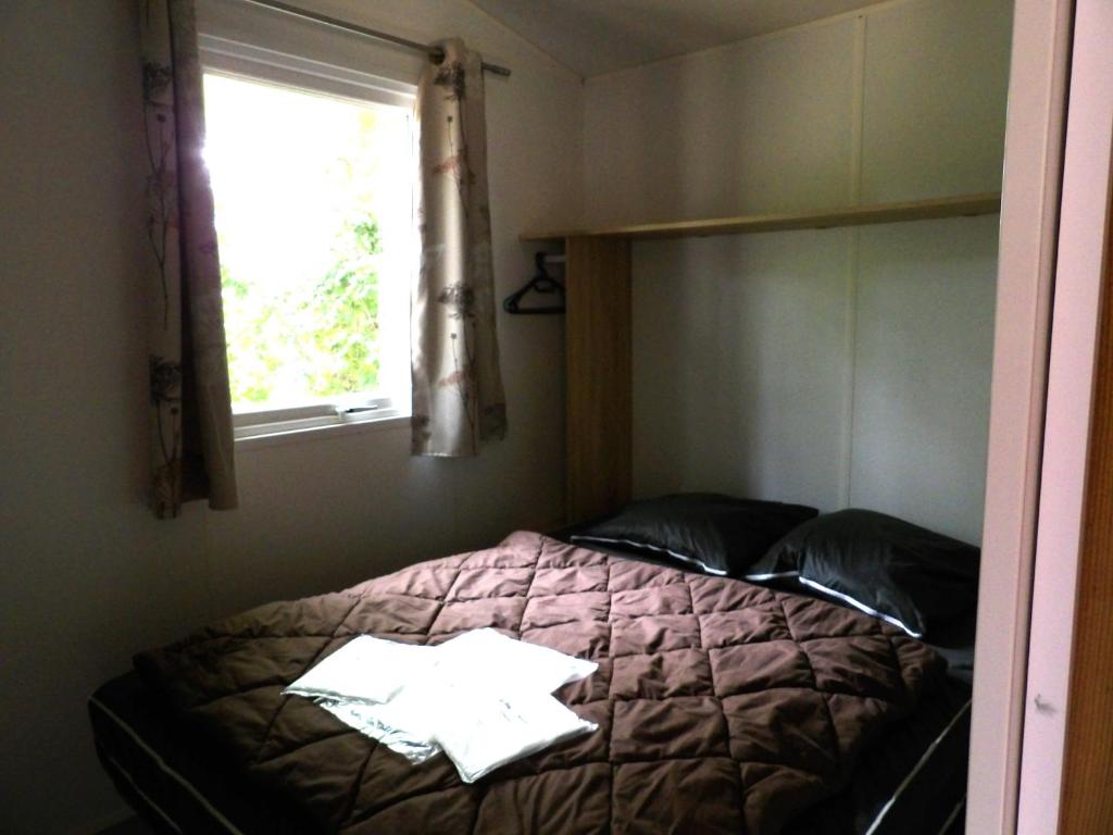 un lit dans une chambre avec une fenêtre et un pare-lit dans l'établissement THITOME, à Limeuil