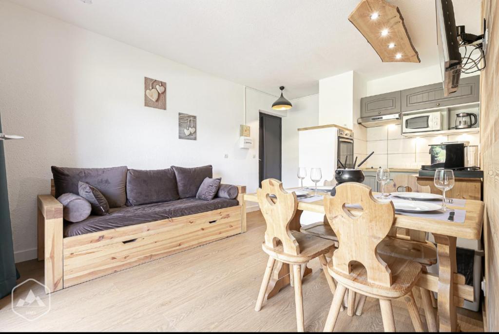 un salon avec un canapé, une table et des chaises dans l'établissement La Norma en Terrasse, à Villarodin-Bourget