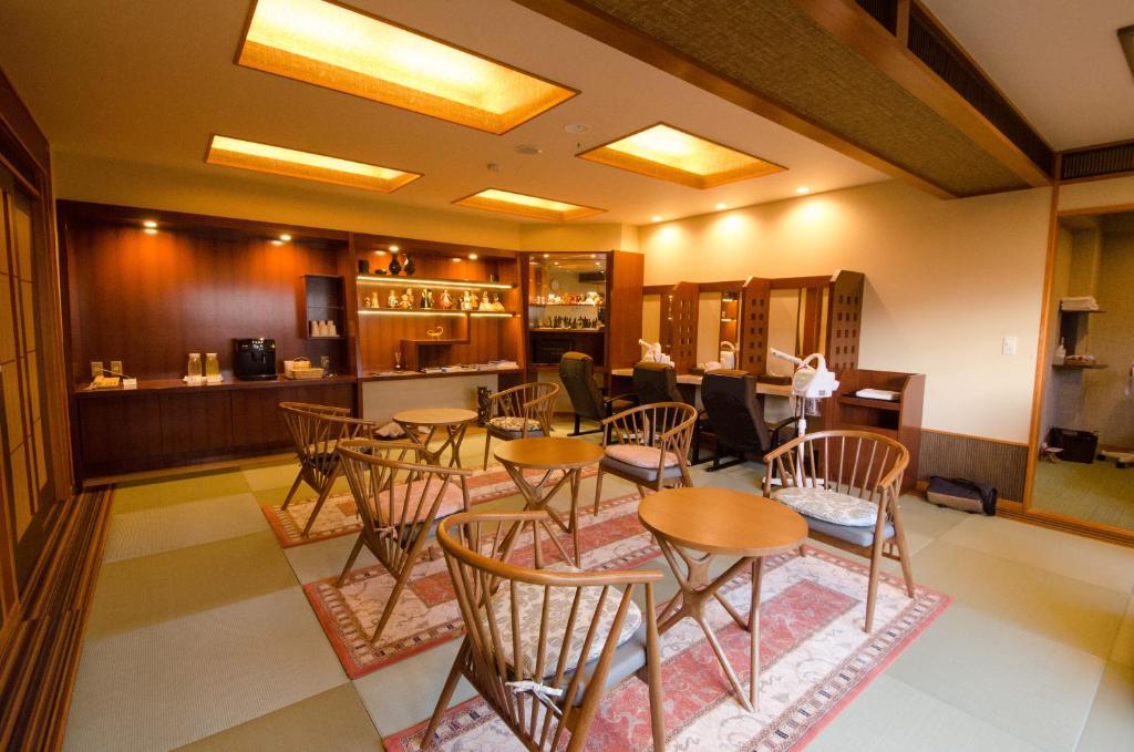 un restaurant avec des tables et des chaises et un bar dans l'établissement Inatori Tokai Hotel Yuen, à Higashiizu