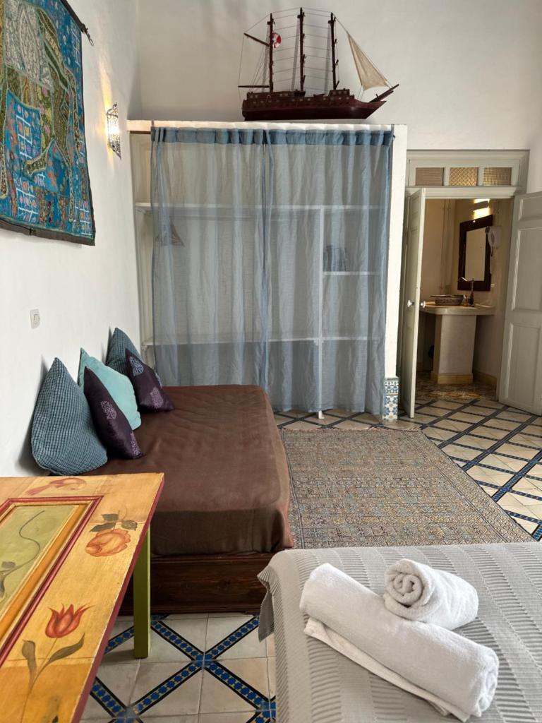 un salon avec un lit et une table dans l'établissement Riad Al Zahia, à Essaouira